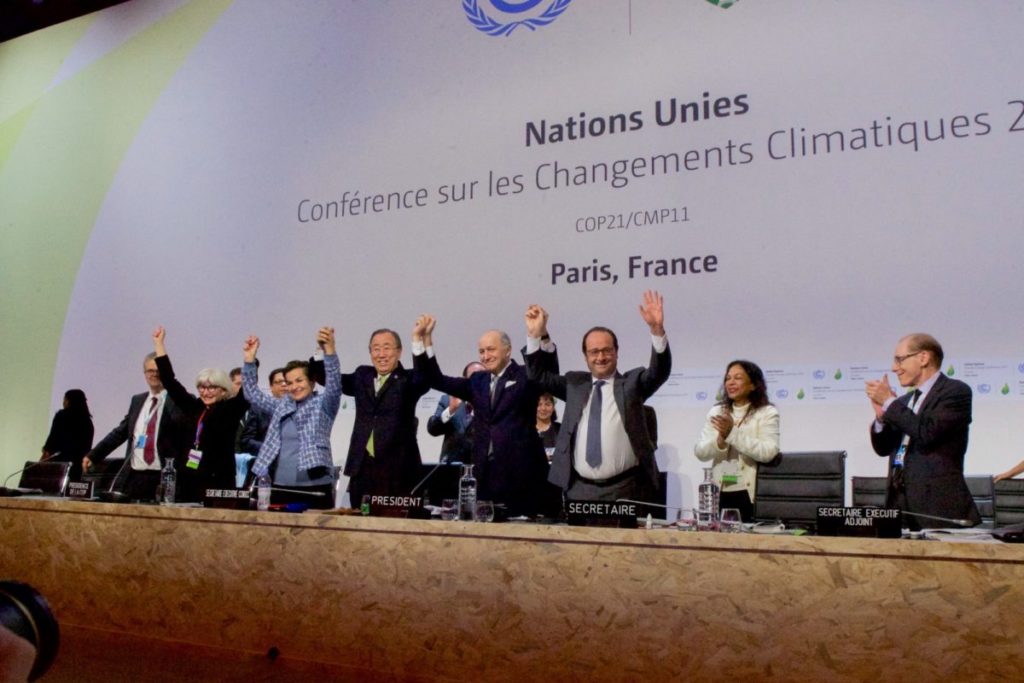 World leaders hold hands to celebrate the Paris climate agreement