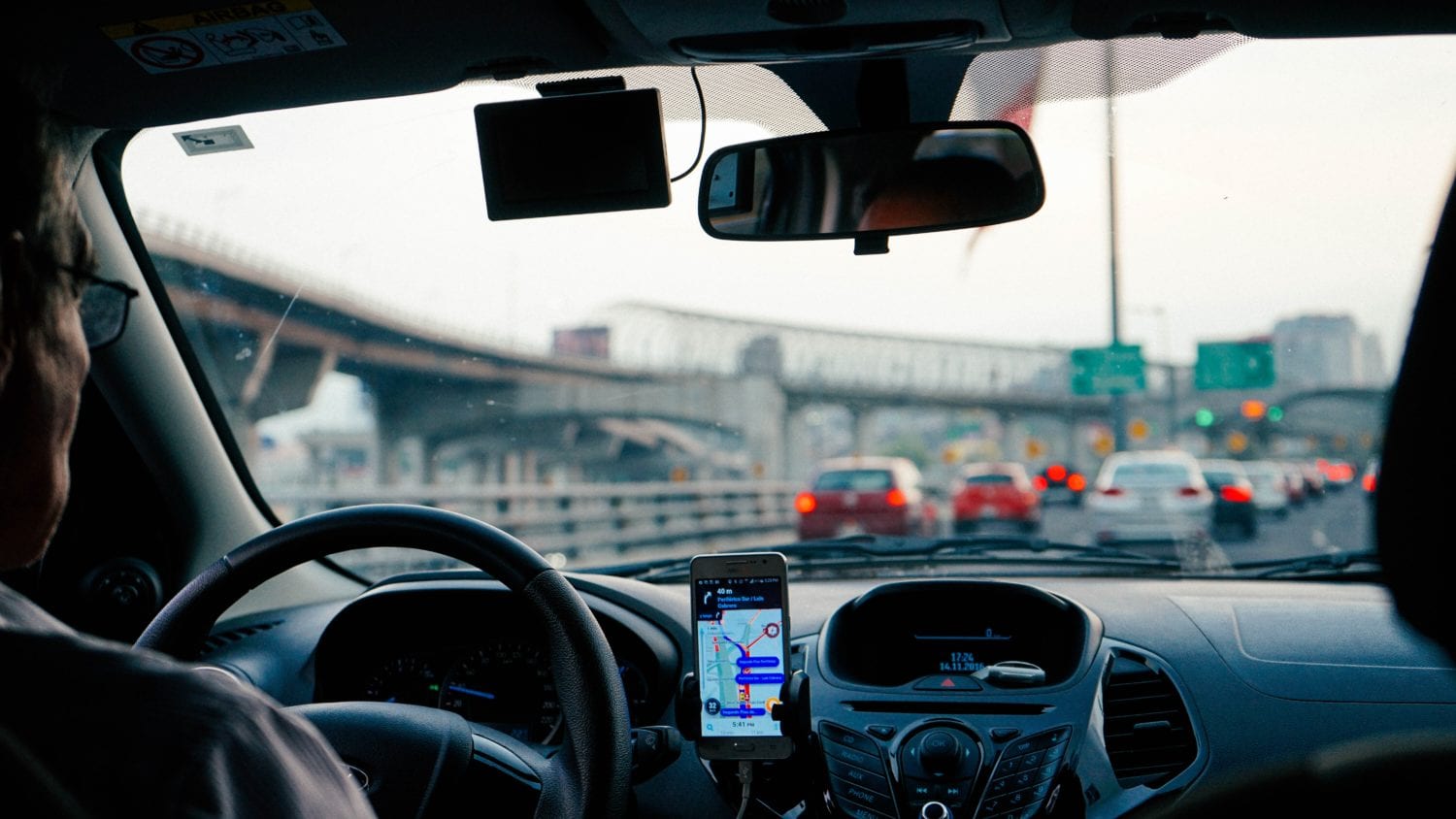 Smart phone showing navigation on a car dashboard