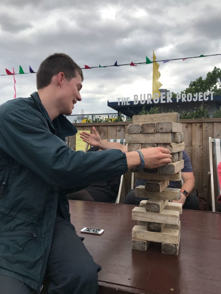 Jerome playing jenga on a rooftop - on our team day