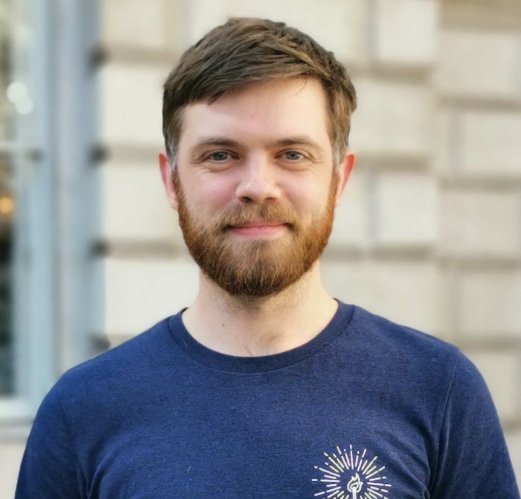 Tommy Ferry - Photograph of a man standing wearing a blue tshirt