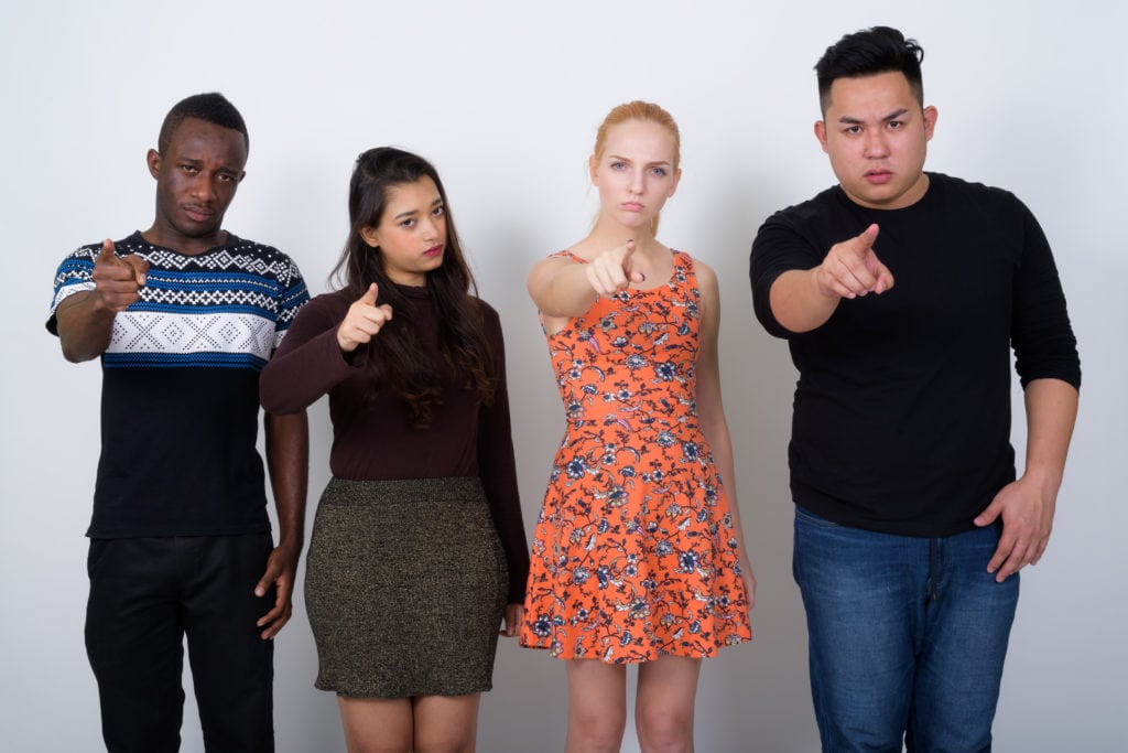 Diverse group of young people pointing in your face